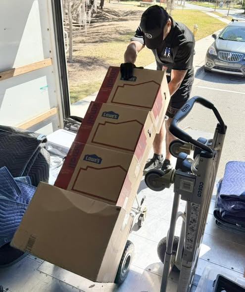 Arnold Brothers mover rolling packed boxes into a moving truck
