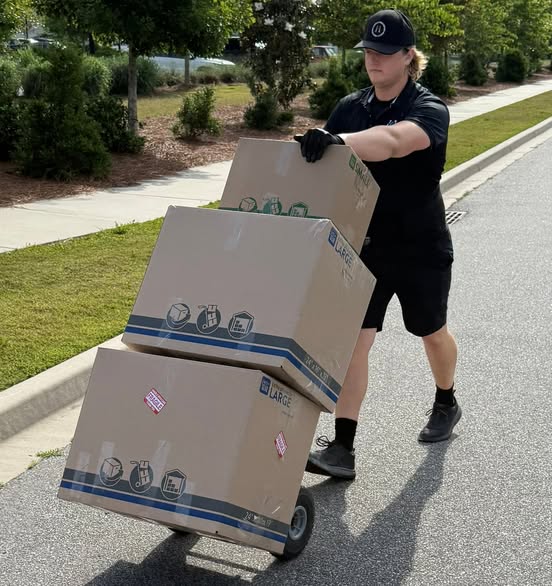 Arnold Brothers mover transporting packed boxes on a hand truck